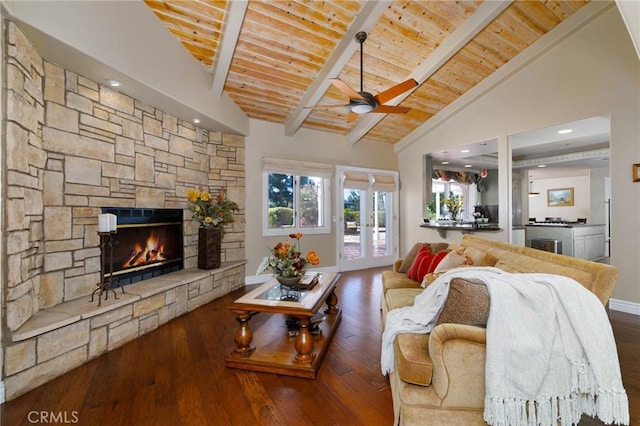 living area with a ceiling fan, plenty of natural light, wood finished floors, and a fireplace