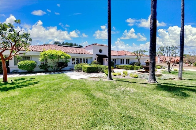 mediterranean / spanish-style home with stucco siding, a tile roof, and a front yard