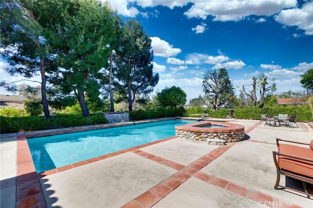 view of swimming pool featuring a patio area and a pool with connected hot tub