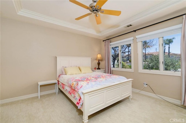 bedroom with crown molding, a tray ceiling, and multiple windows