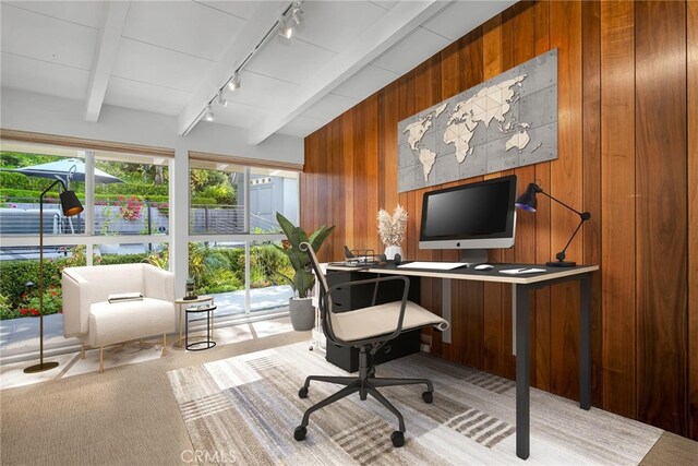 office featuring wooden walls, rail lighting, beamed ceiling, and carpet