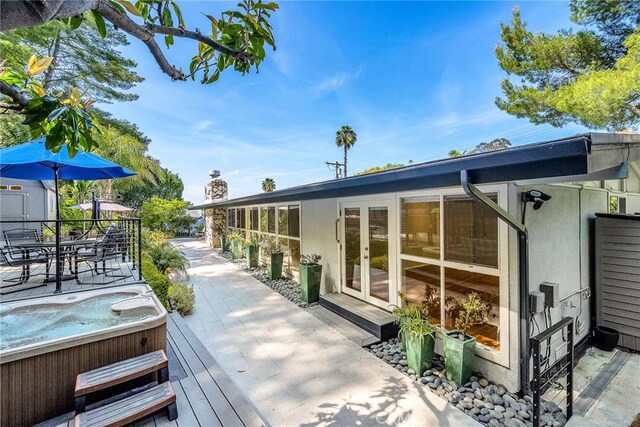 wooden deck featuring french doors and a hot tub
