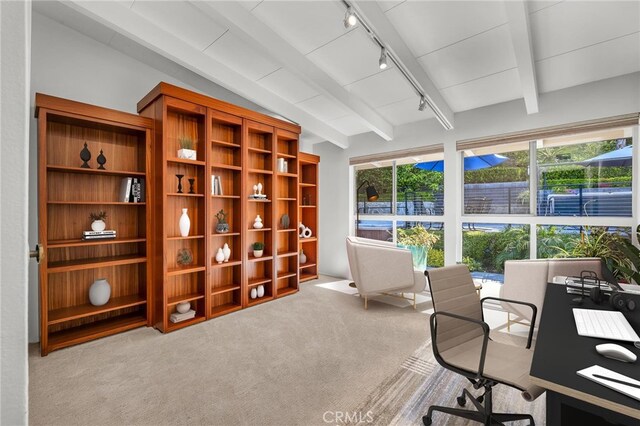 carpeted home office featuring track lighting and vaulted ceiling with beams