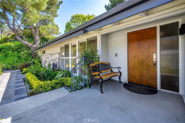 property entrance featuring stone siding and stucco siding