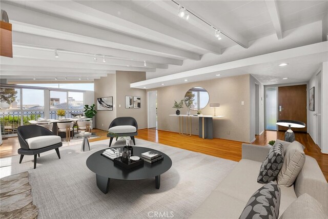 living room with track lighting, recessed lighting, wood finished floors, and beam ceiling