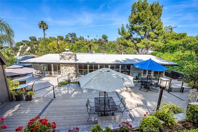 back of house featuring a wooden deck and outdoor dining space