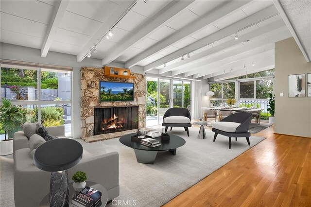 sunroom / solarium with a healthy amount of sunlight, beamed ceiling, and rail lighting