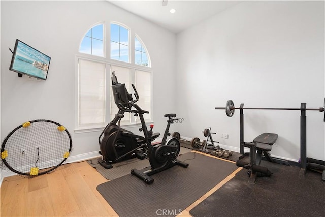 exercise room with baseboards, recessed lighting, and wood finished floors