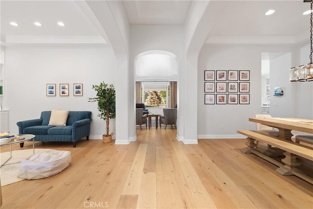 interior space featuring recessed lighting, arched walkways, baseboards, and light wood-type flooring