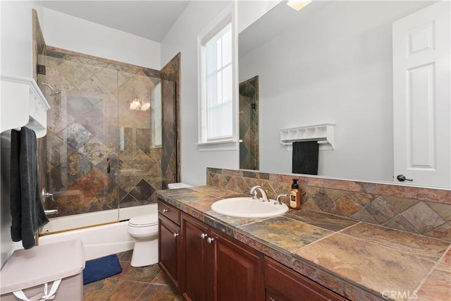 full bathroom featuring toilet, enclosed tub / shower combo, and vanity