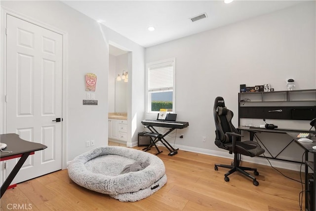 office space with recessed lighting, baseboards, visible vents, and wood finished floors