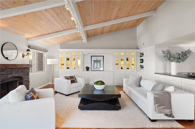 living room featuring wood ceiling, a fireplace, wood finished floors, track lighting, and lofted ceiling with beams