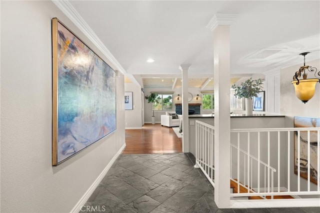 corridor with crown molding, recessed lighting, baseboards, stone tile flooring, and ornate columns
