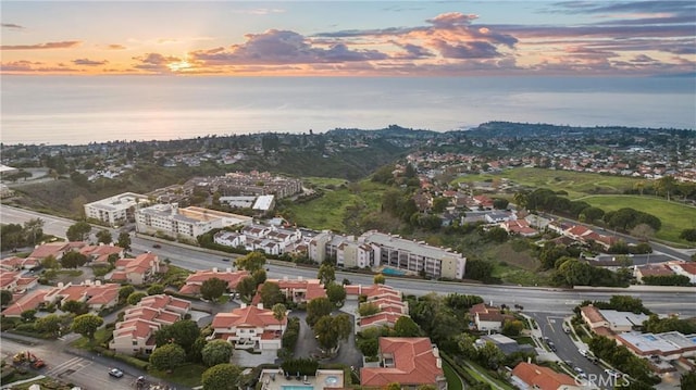 aerial view at dusk featuring a water view