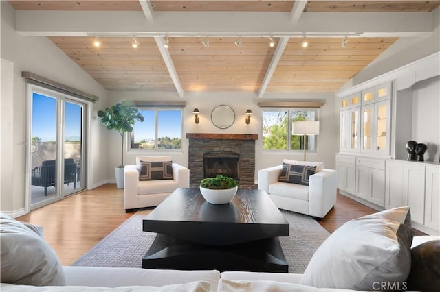 living room featuring vaulted ceiling with beams, rail lighting, and wood finished floors