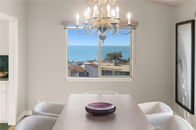 dining space featuring a water view and a chandelier