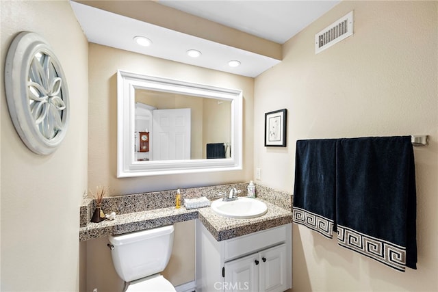 bathroom featuring recessed lighting, vanity, toilet, and visible vents