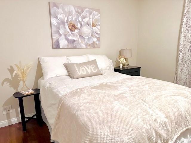 bedroom featuring baseboards and wood finished floors