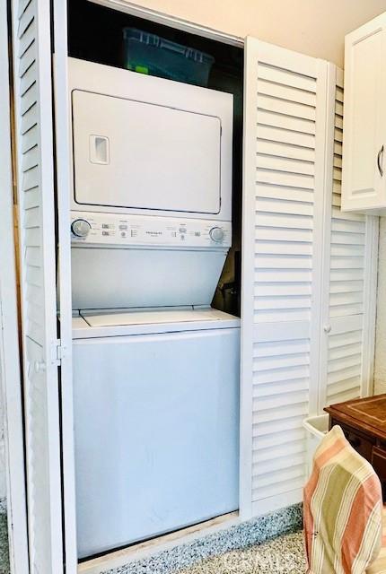 laundry area featuring stacked washer / drying machine and laundry area