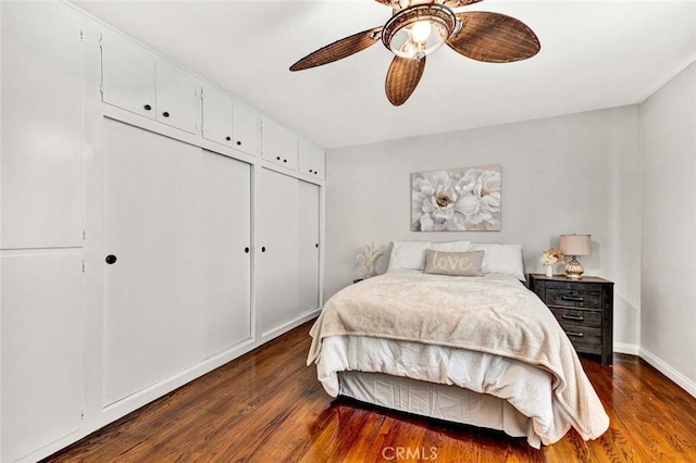 bedroom featuring baseboards, ceiling fan, a closet, and wood finished floors