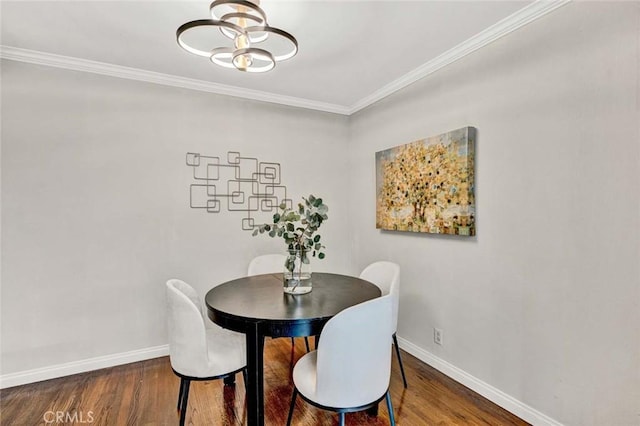 dining area featuring baseboards, ornamental molding, and wood finished floors