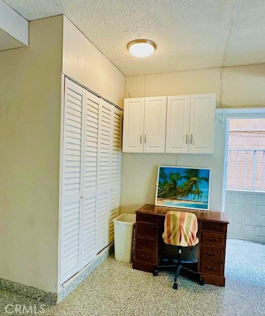 office with a textured ceiling and light speckled floor