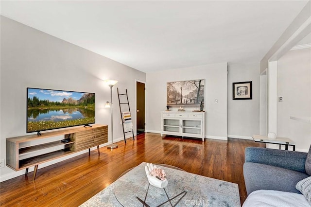 living area featuring baseboards and wood finished floors