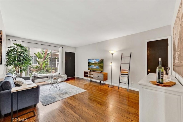 living area featuring baseboards and wood finished floors