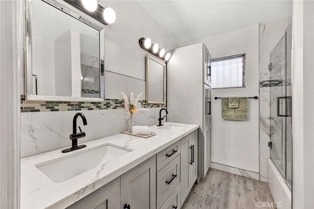 2049 E 3rd St Unit 3, Long Beach, CA 90814 - full bath featuring double vanity, a sink, wood finished floors, and bath / shower combo with glass door