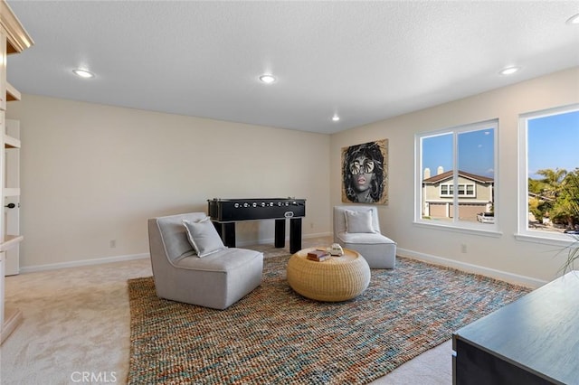 sitting room with light colored carpet, recessed lighting, and baseboards