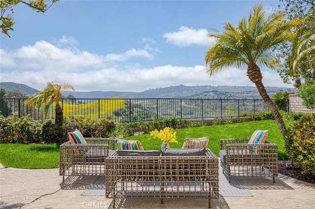 view of patio / terrace featuring outdoor lounge area, a mountain view, and a fenced backyard
