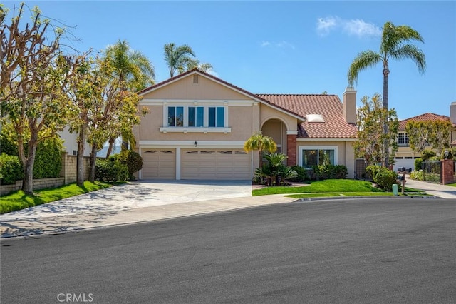 traditional home featuring a tile roof, a garage, fence, concrete driveway, and stucco siding