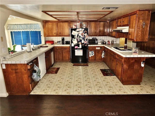 3915 Valencia Ave, San Bernardino, CA 92404 - kitchen featuring under cabinet range hood, tile countertops, visible vents, and black appliances