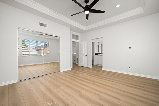 17 Calvados, Newport Coast, CA 92657 - unfurnished bedroom with visible vents, crown molding, light wood-type flooring, a raised ceiling, and baseboards