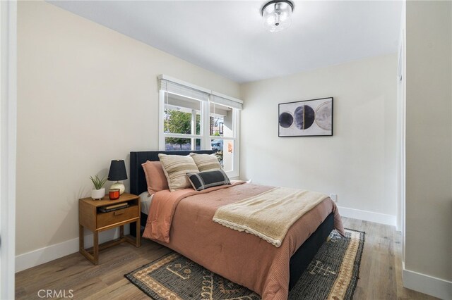 bedroom featuring baseboards and wood finished floors