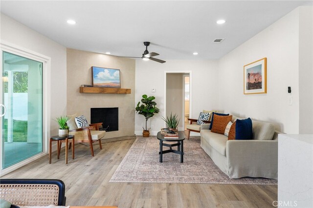 living area featuring a ceiling fan, recessed lighting, a fireplace with flush hearth, wood finished floors, and visible vents