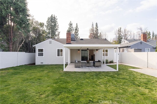 rear view of property featuring ceiling fan, outdoor lounge area, a fenced backyard, a chimney, and a patio area
