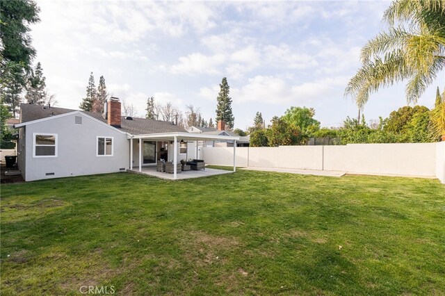 back of property featuring a fenced backyard, a patio, a chimney, and a yard