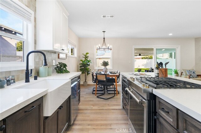 kitchen with appliances with stainless steel finishes, plenty of natural light, a sink, and visible vents