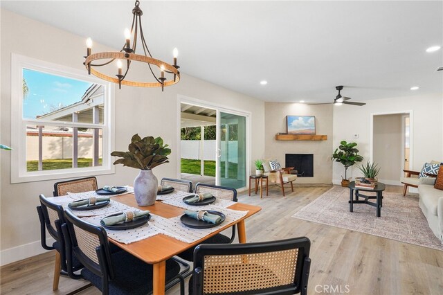 dining area featuring recessed lighting, baseboards, a fireplace, and light wood finished floors