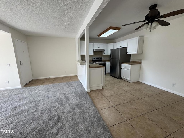 1300 Saratoga Ave Unit 2204, Ventura, CA 93003 - kitchen with dark countertops, freestanding refrigerator, white cabinetry, a ceiling fan, and light tile patterned floors