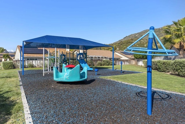 community playground featuring fence and a yard