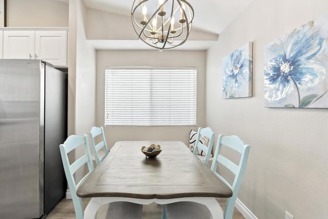 dining space with baseboards, a notable chandelier, and vaulted ceiling