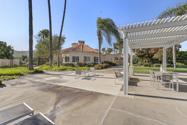 view of home's community with fence, a pergola, a patio area, and uncovered parking