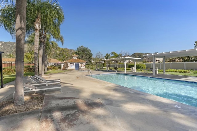 community pool featuring a pergola, fence, and a patio