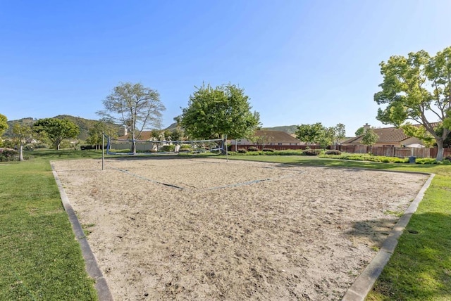 view of home's community with a lawn, fence, and volleyball court