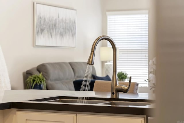 interior details featuring a sink, dark countertops, and white cabinetry