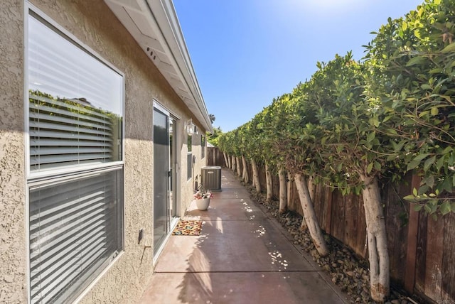 4972 Lake Shore Ct, Fallbrook, CA 92028 - view of side of home with cooling unit, stucco siding, a fenced backyard, and a patio