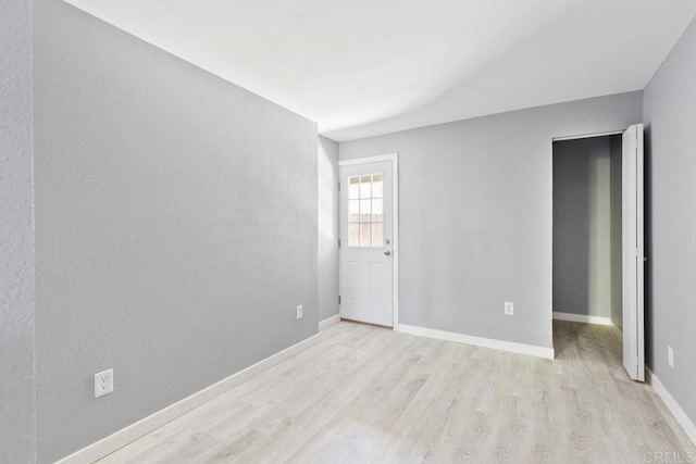 unfurnished room featuring baseboards and wood finished floors