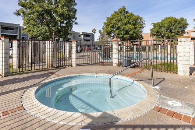 view of pool featuring a hot tub and fence